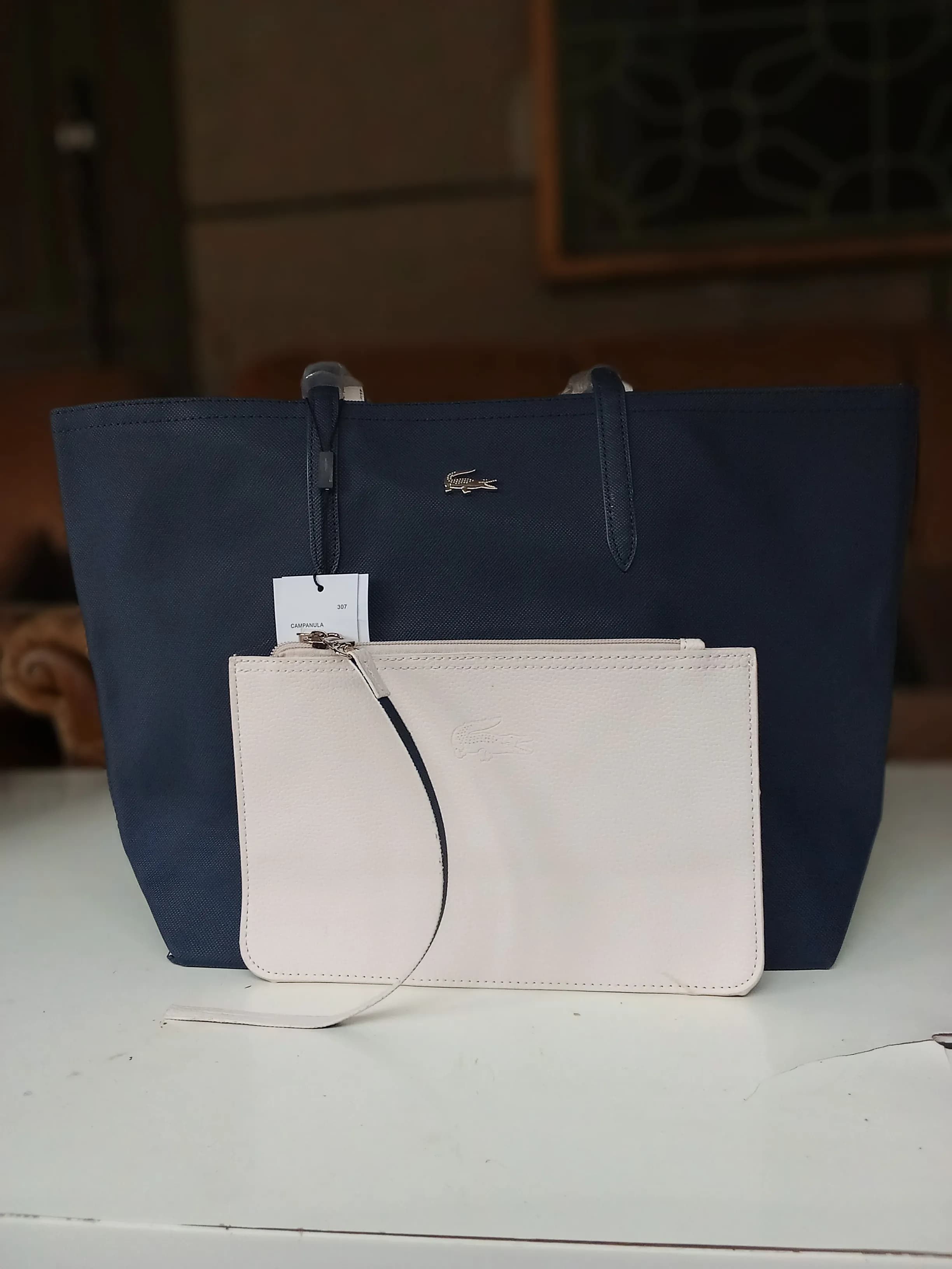 Le produit sac lacoste avec la pochette bleue nuit rose clair